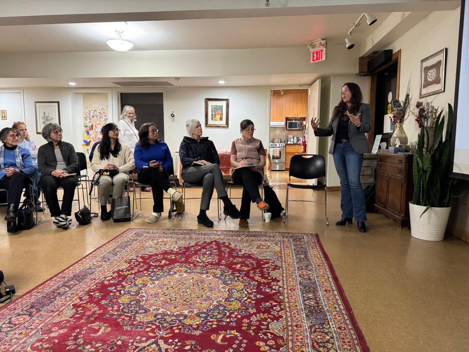 Friends gathered in a circle for thoughtful discussion in a warm, sunlit room